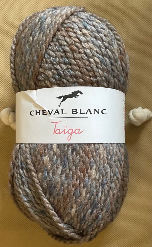 Pelote de laine 'Taïga' de Cheval Blanc dans des tons gris-brun avec des mouchetures bleues, avec étiquette.