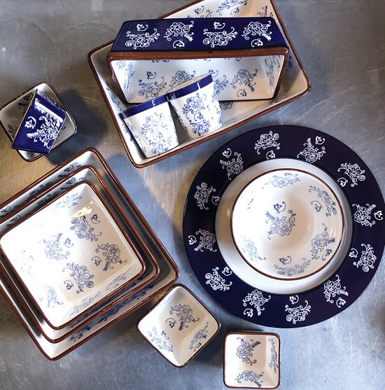 Wit servies met blauw bloemenpatroon en bruine rand. Twee schaaltjes, een presenteerschaal en een kom.