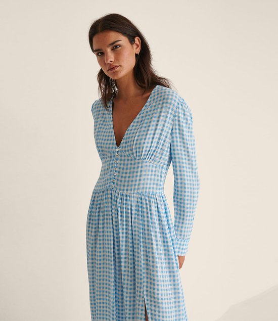 Mannequin portant une robe midi à manches longues à carreaux bleus et blancs, avec un décolleté en V et des boutons.