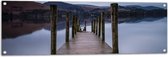 WallClassics - Tuinposter – Vlonder over Water bij Kaal Gebergte - 120x40 cm Foto op Tuinposter  (wanddecoratie voor buiten en binnen)
