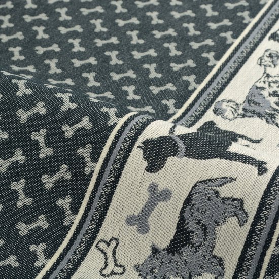 Gros plan d'un torchon gris avec un motif d'os et une bordure décorative avec des chiens.