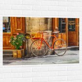 WallClassics - Muursticker - Oranje Fiets bij Stenen Gebouw - 105x70 cm Foto op Muursticker