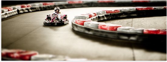 WallClassics - Poster Glanzend – Karter op Indoor Kartbaan - 90x30 cm Foto op Posterpapier met Glanzende Afwerking