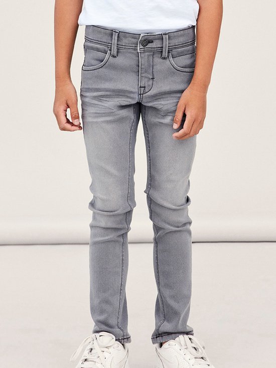 Gedetailleerde voorgrond van een jongetje in een grijze jeans.