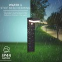 Zwarte staande tuinlamp met bewegingssensor, IP44-classificatie, witte ledverlichting, in de regen op gras.