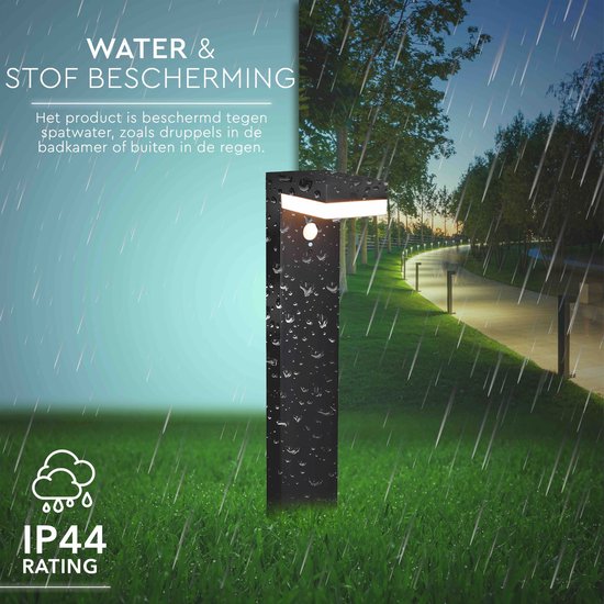 Zwarte staande tuinlamp met bewegingssensor, IP44-classificatie, witte ledverlichting, in de regen op gras.