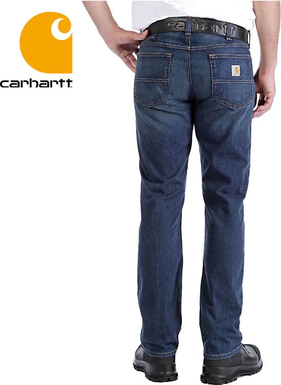 Man met een spijkerbroek van donker denim met een Carhartt-logo op de achterzak.