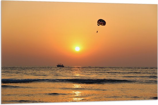 WallClassics - Vlag - Parasailen bij Zonsondergang Boven de Zee - 105x70 cm Foto op Polyester Vlag