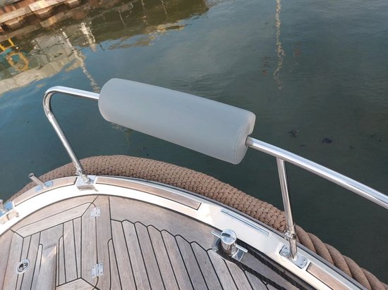 Een grijs relingkussen op de reling van een boot.