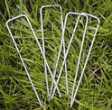 Cinq piquets métalliques argentés en forme de U sont posés sur de l'herbe verte.