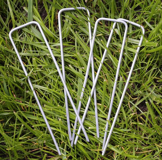 Cinq piquets métalliques argentés en forme de U sont posés sur de l'herbe verte.