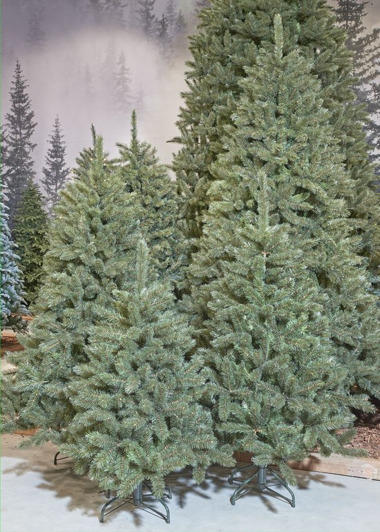 Een groep kunstkerstbomen in verschillende maten, met een bosachtergrond.