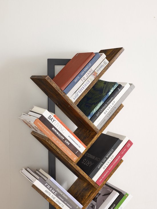 Detail van een boekenkast met houten takken waarop verschillende boeken staan. De ruggen van de boeken hebben titels zoals 'BAY LIVING'.