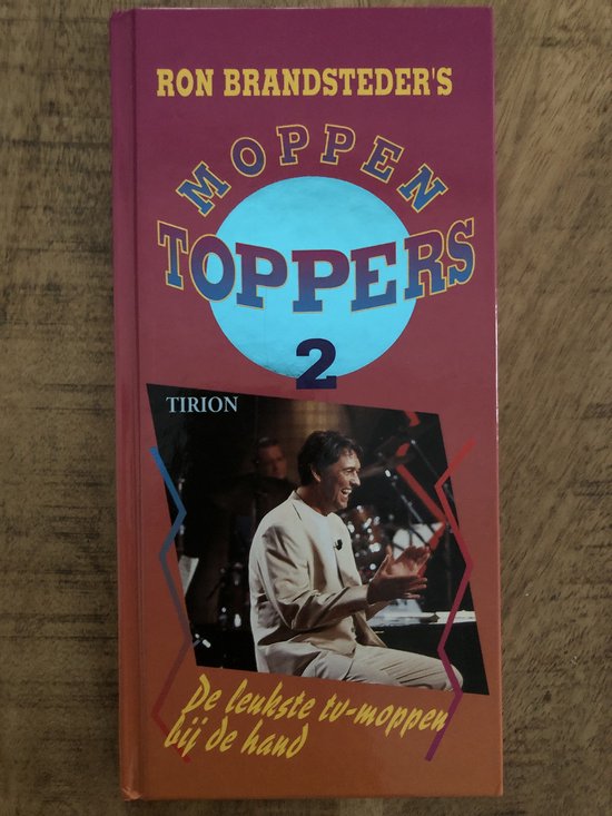Boekhoes met de titel 'Ron Brandsteders Toppers 2'. Een man in een beige pak zit en klapt.