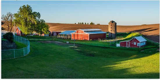 WallClassics - Poster Glanzend – Rode Boerderij met Grasveld - 100x50 cm Foto op Posterpapier met Glanzende Afwerking