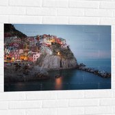 WallClassics - Muursticker - Verlicht Gekleurd dorpje aan Water - 90x60 cm Foto op Muursticker