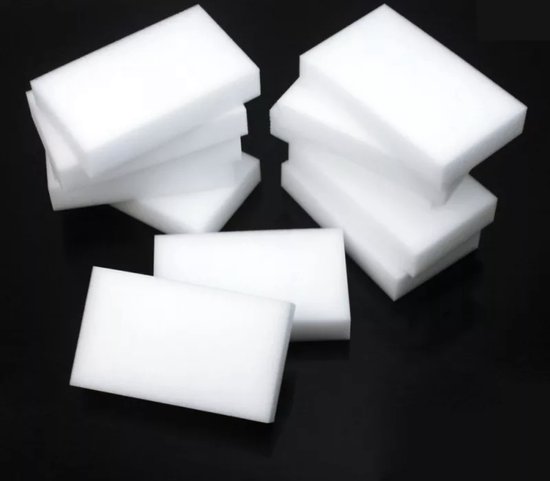 Stapel witte melamine sponzen op zwarte achtergrond.
