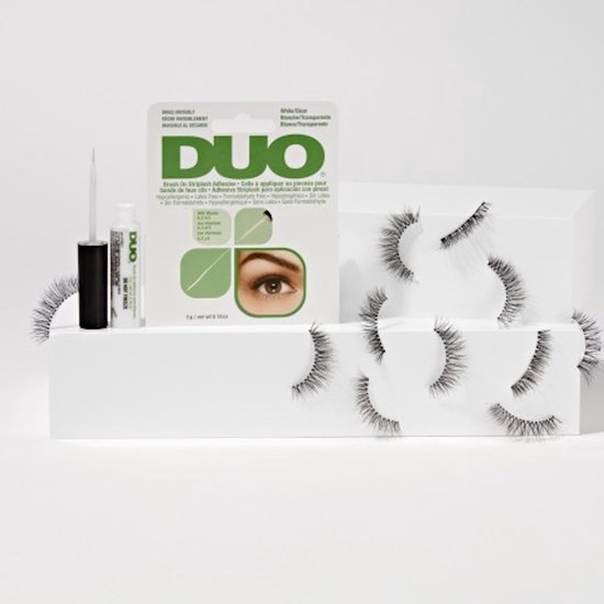 DUO wimperlijm met applicator, verpakking en meerdere nepwimpers op een witte display.