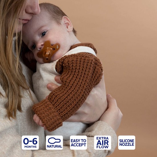 Un bébé avec une sucette Difrax brune de 0-6 mois dans la bouche, avec Extra Air Flow.