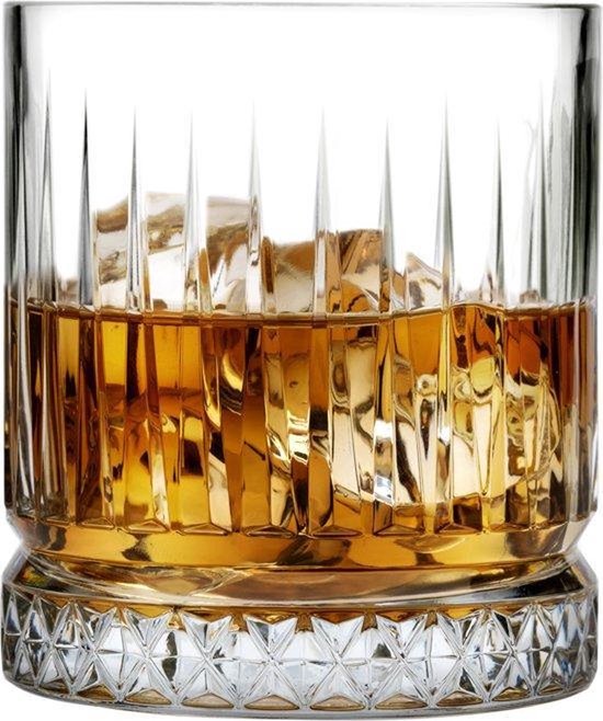 Whisky doré avec des glaçons dans un verre côtelé verticalement avec une base détaillée.
