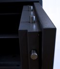 Close-up van de metalen pinnen op de scharnierzijde van een grijze kluis.