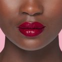 Een vrouw met een glanzende, donkerrode lippenstift.