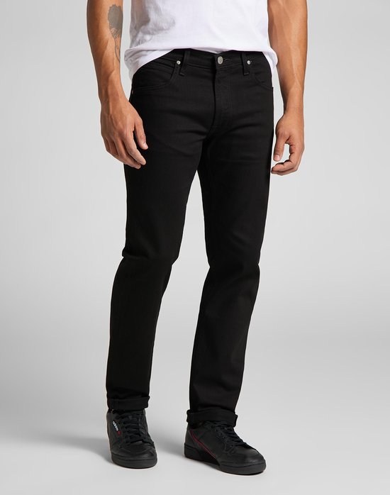 Man in zwarte jeans en zwarte sneakers.