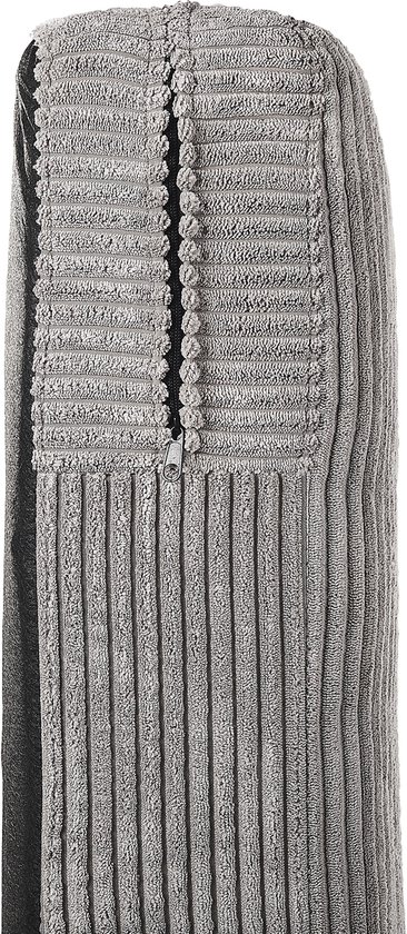 Detail van de armleuning van een fauteuil, bekleed met lichtgrijs corduroy met verticale ribbels.