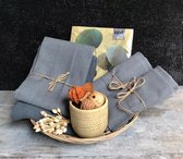 Twee mooie katoenen placemats, 1 theedoek en 1 handdoek in antraciet kleur, 5 bijpassende papieren servetten en een keramieken potje met natuurlijke decoratie.KADO TIP!