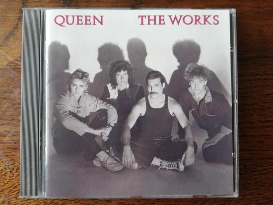 Albumhoes van Queen - The Works met de vier bandleden zittend.