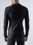 Achterkant van een man in een zwart thermoshirt met lange mouwen en thermobroek.