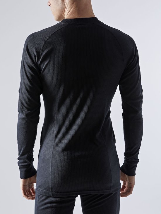 Achterkant van een man in een zwart thermoshirt met lange mouwen en thermobroek.