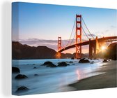 Canvas Schilderij Golden Gate Bridge met blauwe zonsondergang en blauw water - 120x80 cm - Wanddecoratie