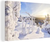 Canvas Schilderij De zon schijnt op een besneeuwd winterlandschap - 120x80 cm - Wanddecoratie