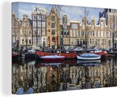 Canvas schilderij 150x100 cm - Wanddecoratie Een rode woonboot in de Amsterdamse gracht - Muurdecoratie woonkamer - Slaapkamer decoratie - Kamer accessoires - Schilderijen