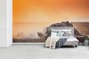 Behang - Fotobehang - Gnoe schopt zand omhoog tijdens een zonsondergang - Breedte 395 cm x hoogte 220 cm
