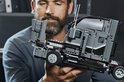 Man met baard houdt de grijze cabine van een LEGO Technic Mack Anthem truck vast.