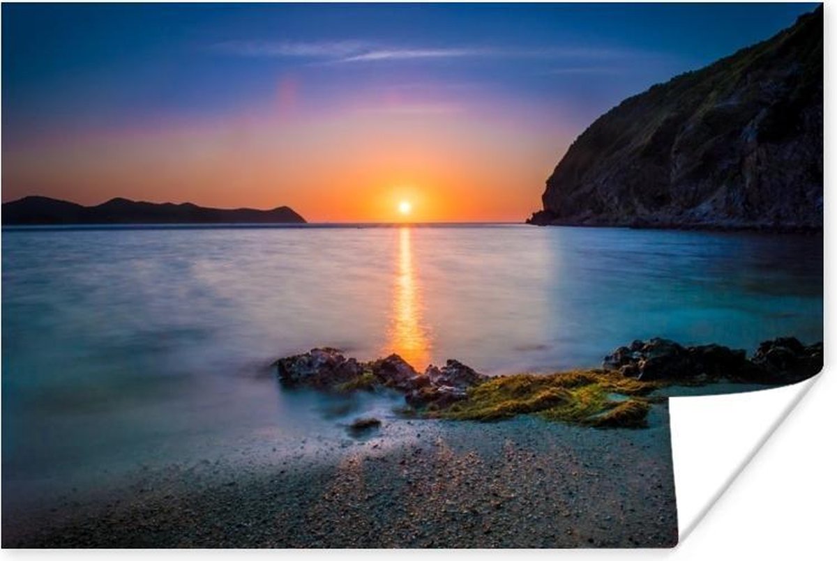 Poster Een romantische foto van de zon die onder gaat bij het strand op