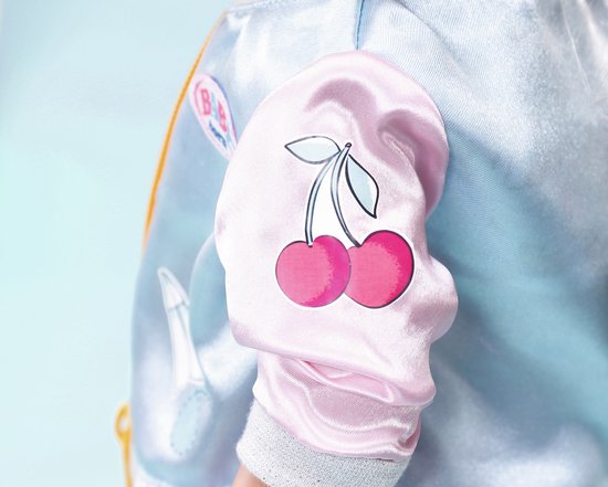 Detail van mouw van lichtblauw jasje met roze print van twee kersen.