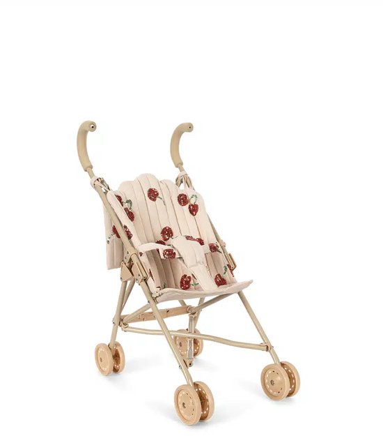 Poussette pour poupée en tissu beige avec un imprimé de cerises rouges à paillettes. Poignées et roues beiges.