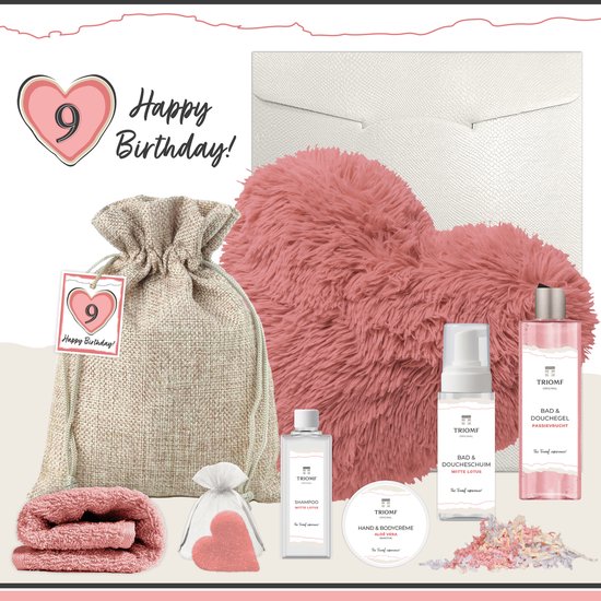 Wellness cadeaupakket voor haar 9e verjaardag: een roze hartvormig kussen, een stoffen zakje met producten, een roze hartvormig zeepje, opgerolde roze handdoek, en luxe bad- en huidverzorgingsproducten van Triomf.