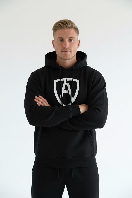 Model draagt een zwarte hoodie met witte AMPORA-logo op de borst en armen over elkaar.