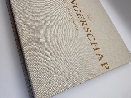 Crème invulboek 'Zwangerschap herinneringen' met gouden tekst op de voorkant, een close-up.