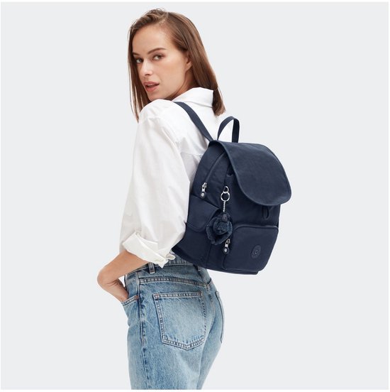 Model draagt een donkerblauwe Kipling rugzak.