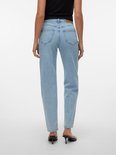 Model van achteren gezien in lichtblauwe jeans met een hoge taille en rechte pijpen. Draagt zwarte hakken.