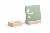 Beige kunststof tegelhouder met groene tegel met tekst 'IT IS WHAT IT IS'.