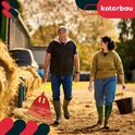 Man met rode bladhark en vrouw met emmer lopen op boerderijterrein.