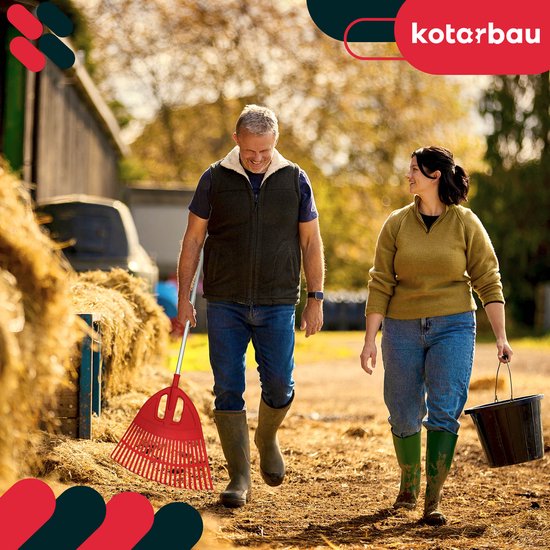 Man met rode bladhark en vrouw met emmer lopen op boerderijterrein.