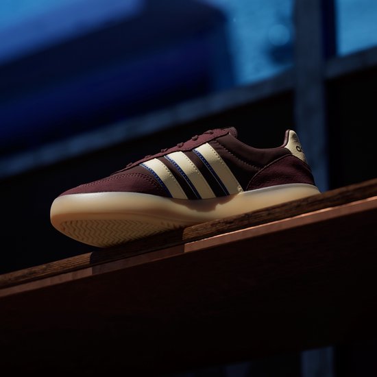 Bordeauxrode sneaker met beige en blauwe strepen, beige zool.