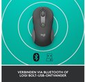 Grijze Logitech M650 muis op een groene ondergrond met witte cirkels.